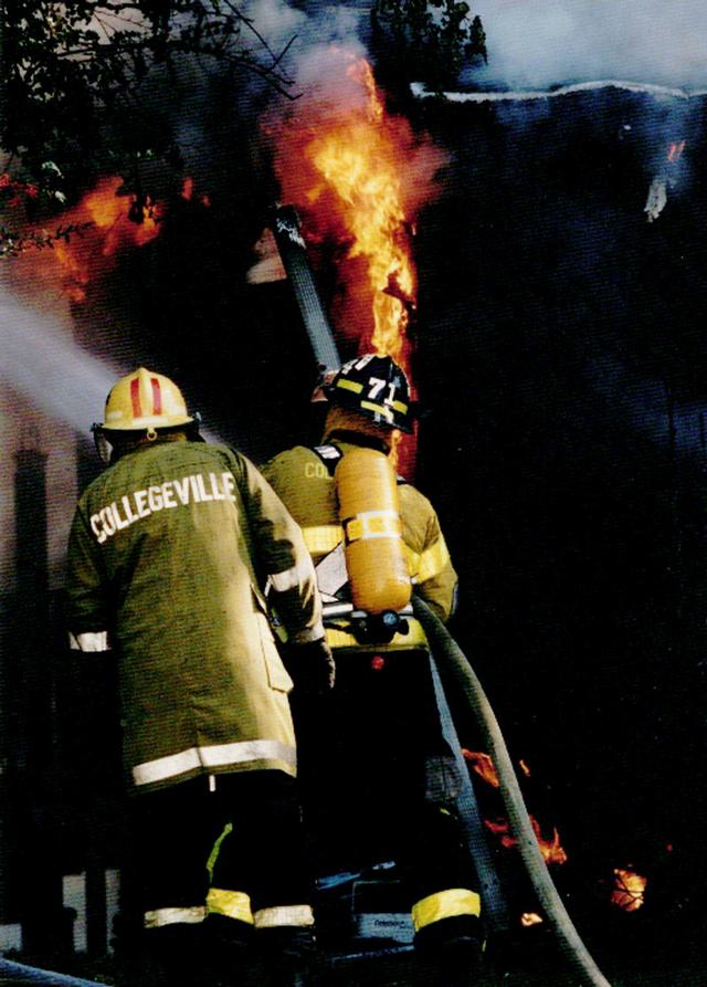 Pictured in the Yellow helmet is Firefighter Bruce Penuel at a working house fire on West First Avenue in Collegeville Borough